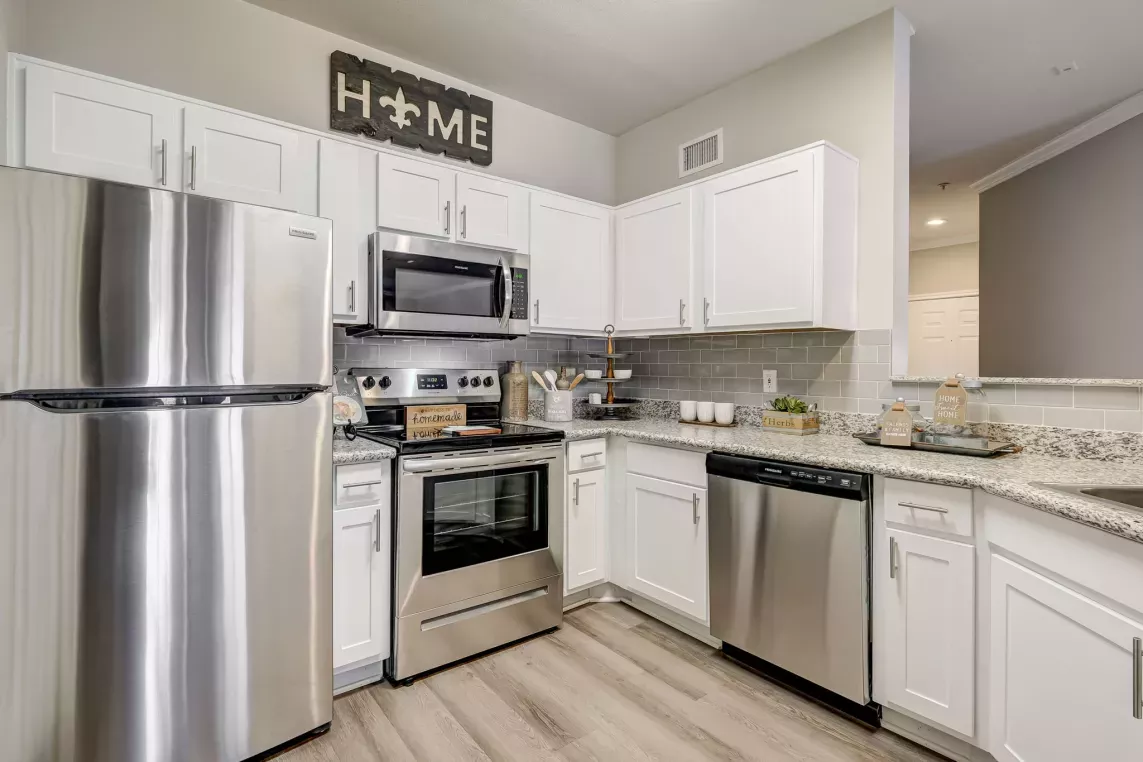 Modern kitchen with stainless steel appliances, granite countertops, and white cabinetry at Gates at Citiplace apartments in Baton Rouge, LA