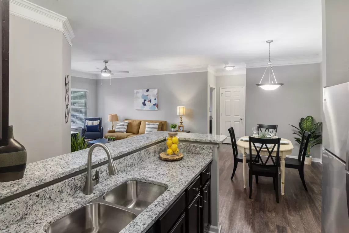 Open-concept view of kitchen, dining area, and living room in a Lauren Ridge apartment.