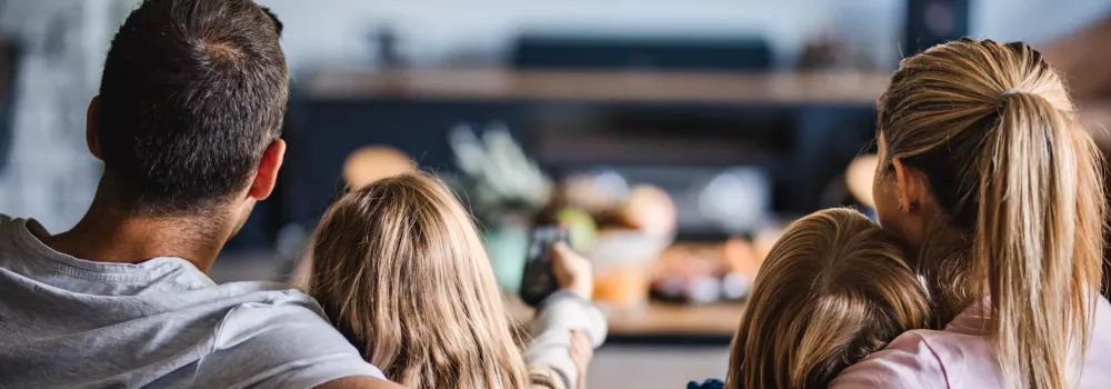 A group of people sitting outdoors, engaging with each other. Among them is a girl with a ponytail, showcasing various clothing styles and expressing interaction.