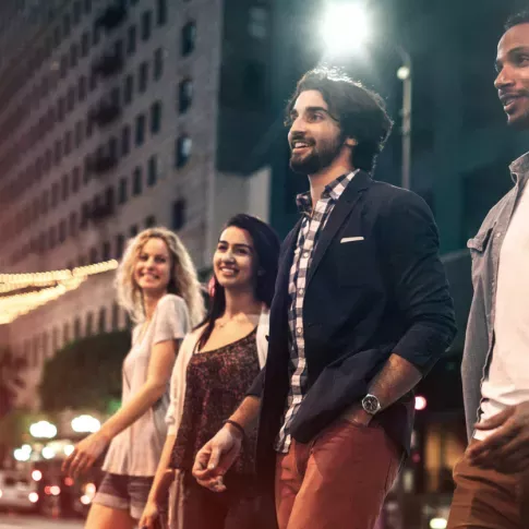 Group of friends enjoying a vibrant night out in a bustling city, surrounded by lively lights and urban energy.