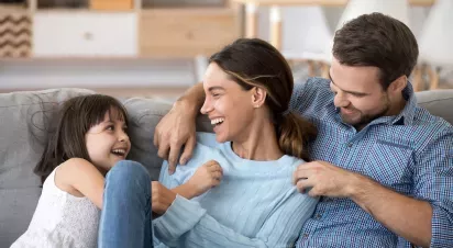 Happy family enjoying quality time together on a cozy sofa, symbolizing comfort and connection in a warm and welcoming home environment.