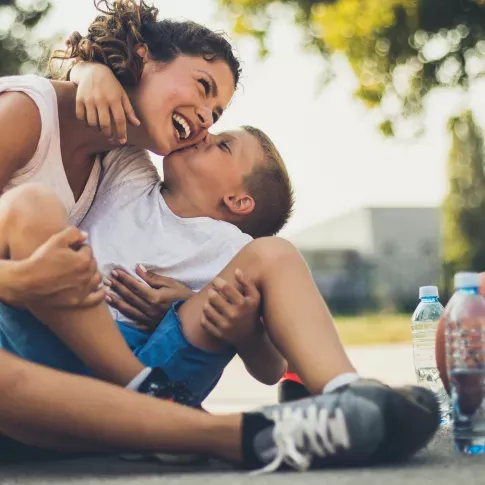  A heartwarming moment shared between a mother and her child enjoying time together outdoors, playing basketball and laughing under the sun. This image reflects the community-friendly atmosphere of the neighborhood, offering a family-oriented environment perfect for making