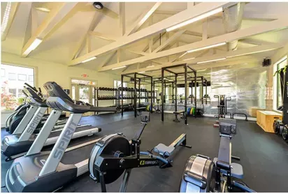 Well-equipped fitness center at Chatsworth Apartments featuring cardio machines, free weights, and a spacious workout area.