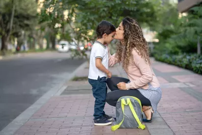 Mother kissing son's forhead before school