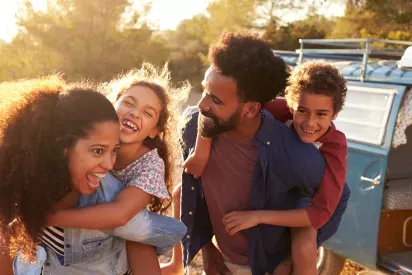 Family laughing together with sunlit background
