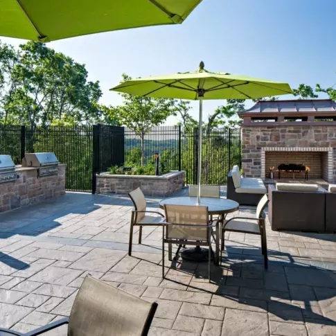 Outdoor fireside lounge with seating and BBQ grilling stations, providing a cozy and scenic setting for social gatherings.