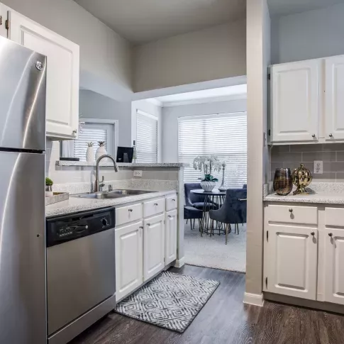 Another angle of the kitchen highlighting the dual sink, breakfast bar, and open floor plan design.