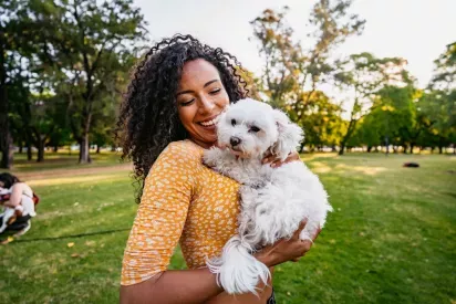 Woman holding a small, long haired dog