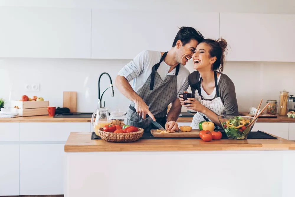 A couple chopping bell peppers into a salad