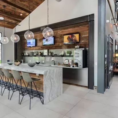Contemporary coffee bar and kitchen space at Riverworks featuring a modern island with barstool seating.