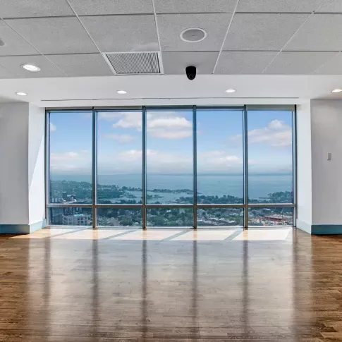 Bright yoga and exercise room with floor-to-ceiling windows showcasing a panoramic cityscape.