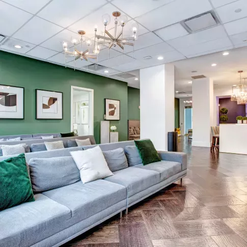 Inviting lounge area with plush seating, green accent walls, and stylish decor for relaxation or social gatherings.
