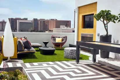 Rooftop lounge area with modern furniture and city views