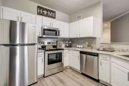 Modern kitchen with stainless steel appliances, granite countertops, and white cabinetry at Gates at Citiplace apartments in Baton Rouge, LA