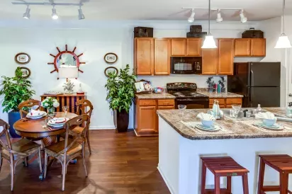Stylish kitchen and dining room at Grandview at Lake Murray featuring wood cabinetry, pendant lighting, and nautical decor.