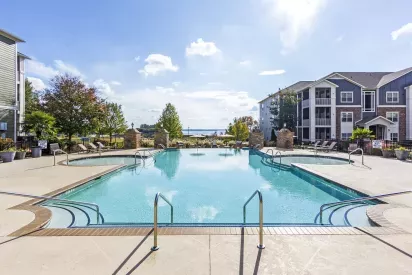 Resort-style swimming pool at Grandview at Lake Murray with tanning ledges and scenic views of the lake in the distance