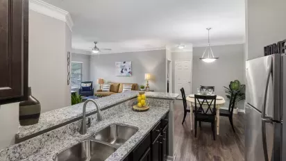 Open-concept view of kitchen, dining area, and living room in a Lauren Ridge apartment.