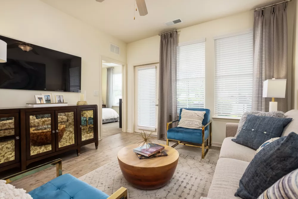 Bright apartment living room with natural light, neutral décor, and access to private bedroom at Avery Turkey Creek.