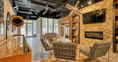 Bright game room with fireplace and TV for residents to enjoy in Irving, Texas.