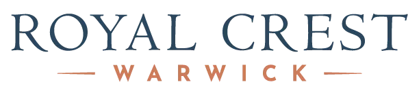 "ROYAL CREST" logo in dark blue, with "WARWICK" in smaller orange text, flanked by horizontal orange lines.