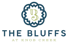 Logo: "The Bluffs at Knob Creek" text with an ornate blue shape surrounding a green "B".