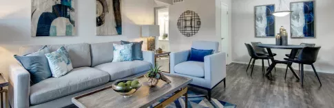 1. A cozy living room with a gray sofa, decorative blue cushions, and modern wall art.  Let me know if you need alt texts for additional images or revisions!