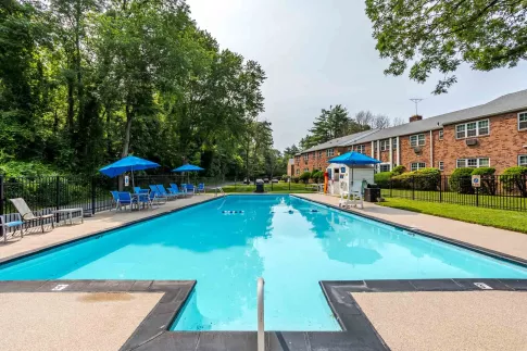 Expansive resort-style pool with plenty of seating and umbrellas for residents to enjoy at Scudder Falls.