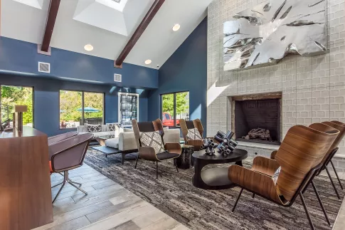 Modern lobby with blue walls, vaulted ceiling, fireplace, and stylish seating area.