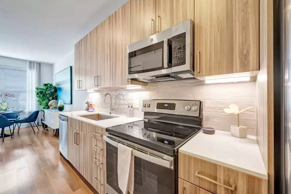 A well-designed kitchen featuring stainless-steel appliances, quartz countertops, and elegant wood cabinetry for a modern touch.