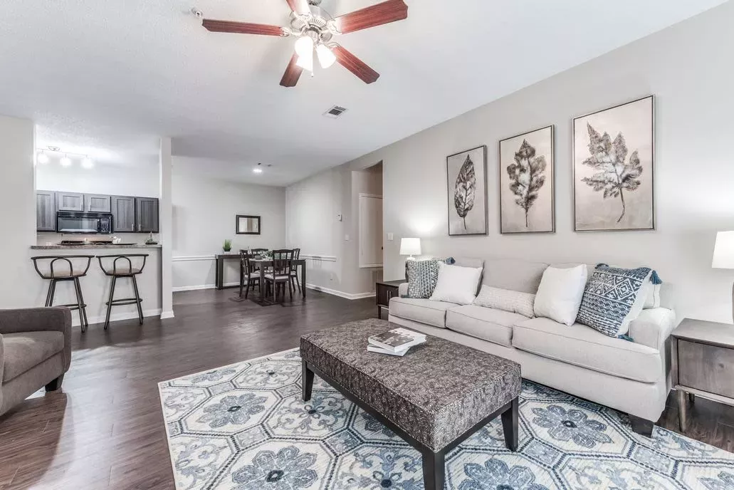 Spacious and beautifully decorated living room at The Landings of Conroe, offering an open-concept design with cozy seating and a dining area.