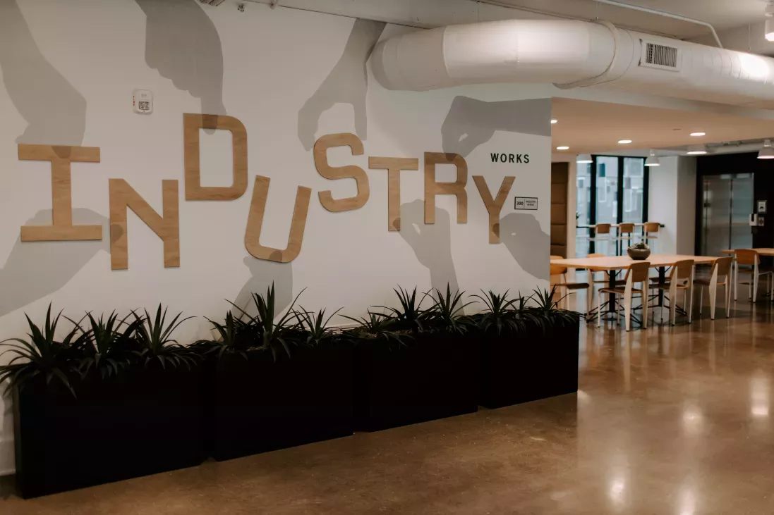 A stylish coworking space in Industry Columbus Apartments with a bold "Industry Works" wall design, contemporary seating, and an open-concept layout for productivity and collaboration.