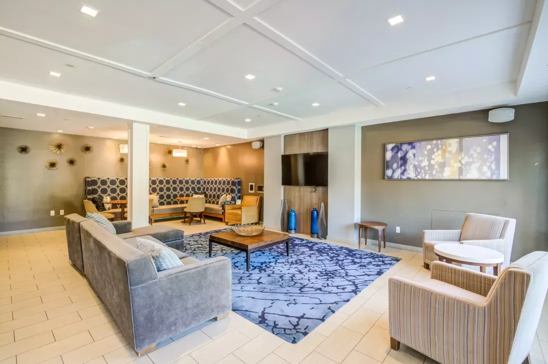 Large, open Clubhouse with multiple TVs, and ample seating for residents.