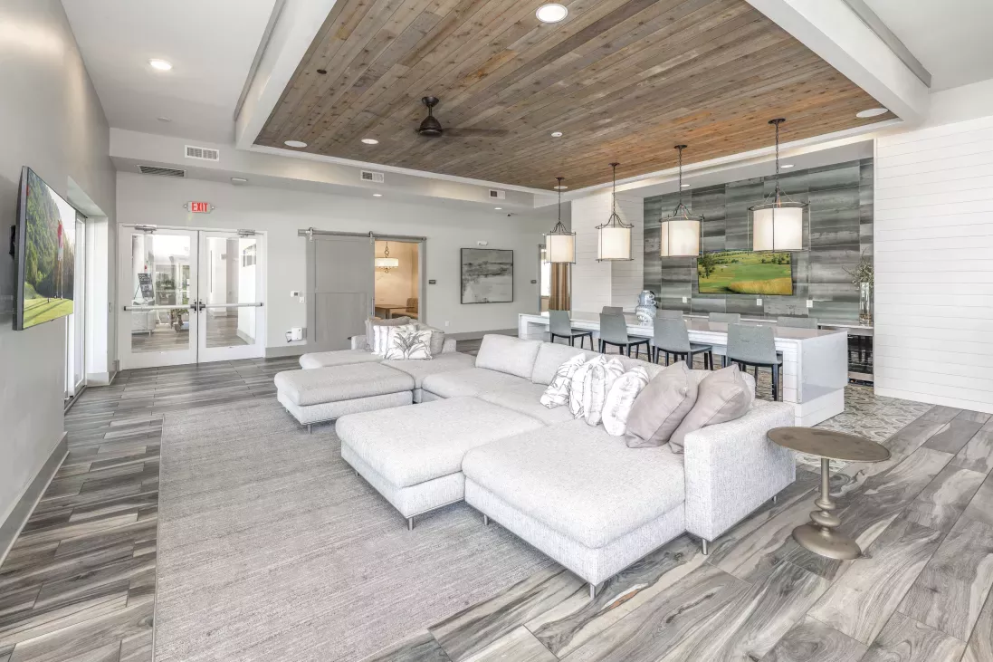 Cozy clubhouse with large, stylish couch and flatscreen TV. 