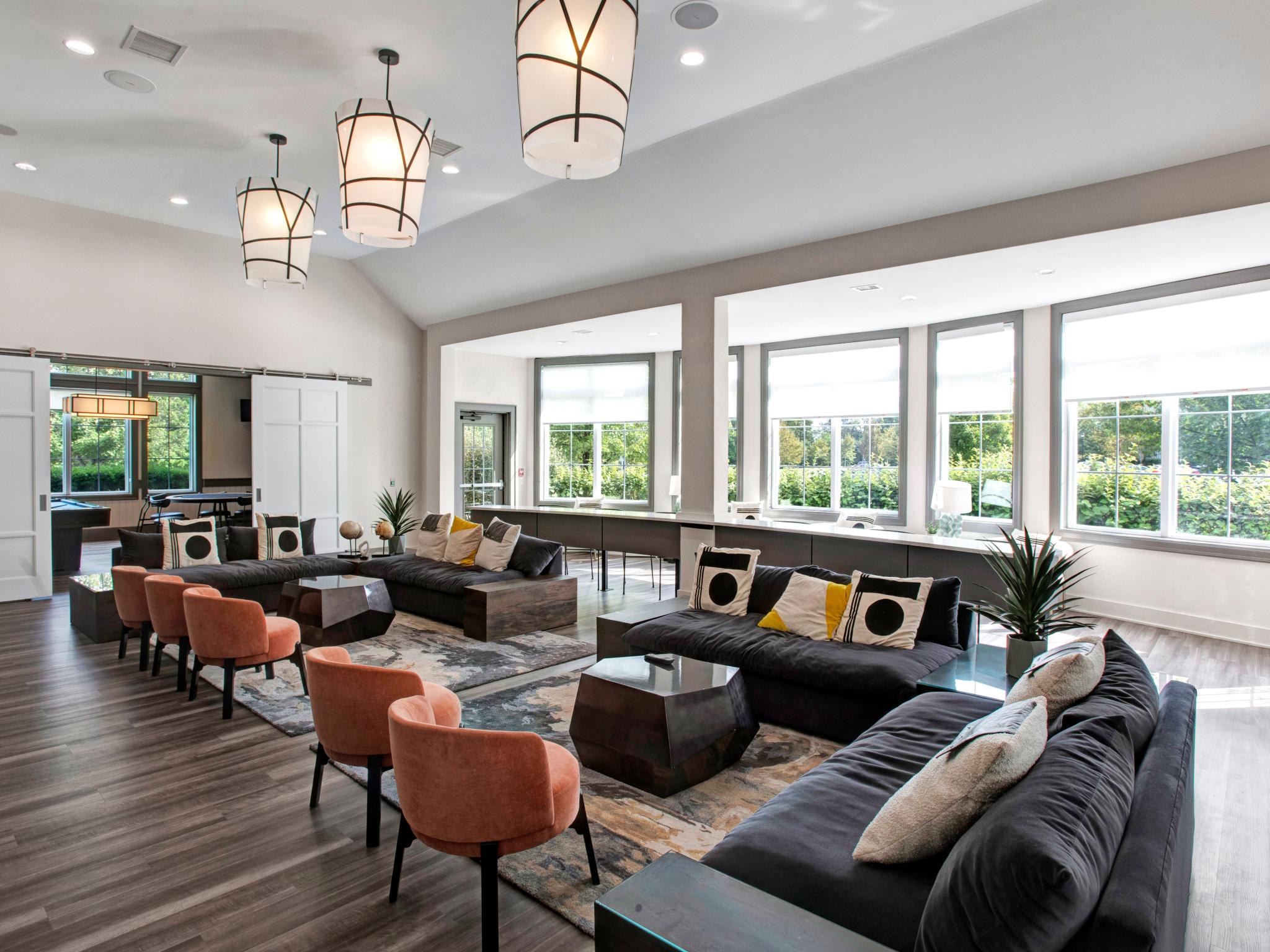 Spacious resident lounge with stylish seating, large windows for natural light, and contemporary design at The Grove Somerset Apartments.