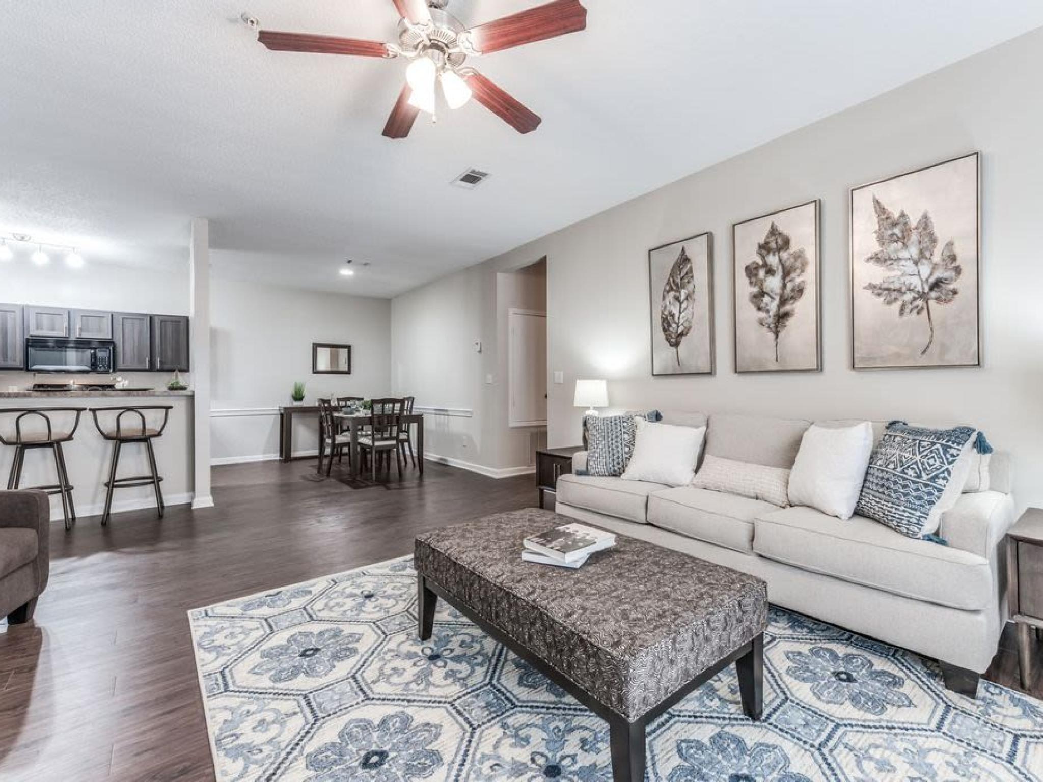 Spacious and beautifully decorated living room at The Landings of Conroe, offering an open-concept design with cozy seating and a dining area.