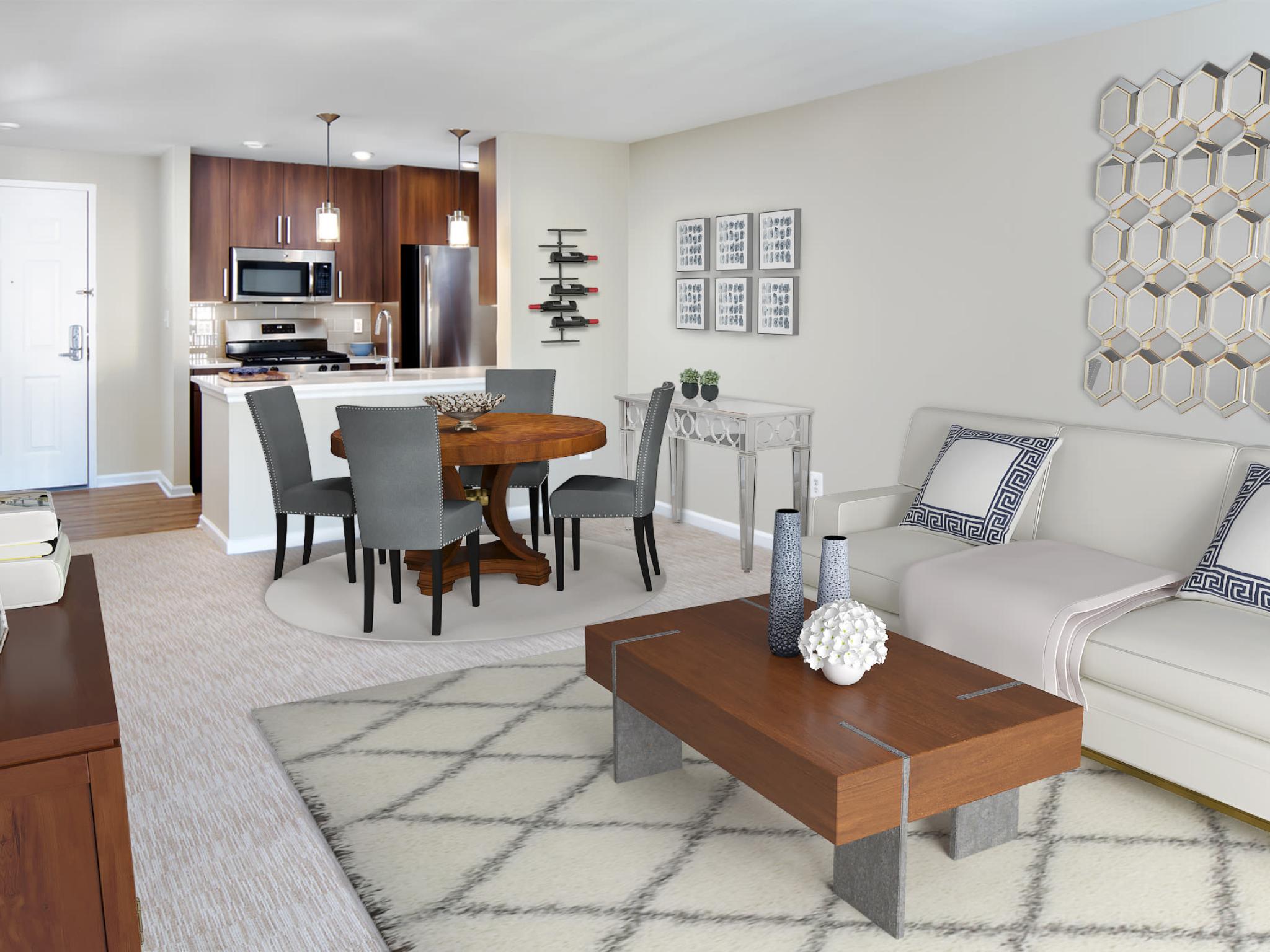 A bright and elegantly furnished living space with an open-concept kitchen, stainless steel appliances, and modern décor at The Mark at Mamaroneck.