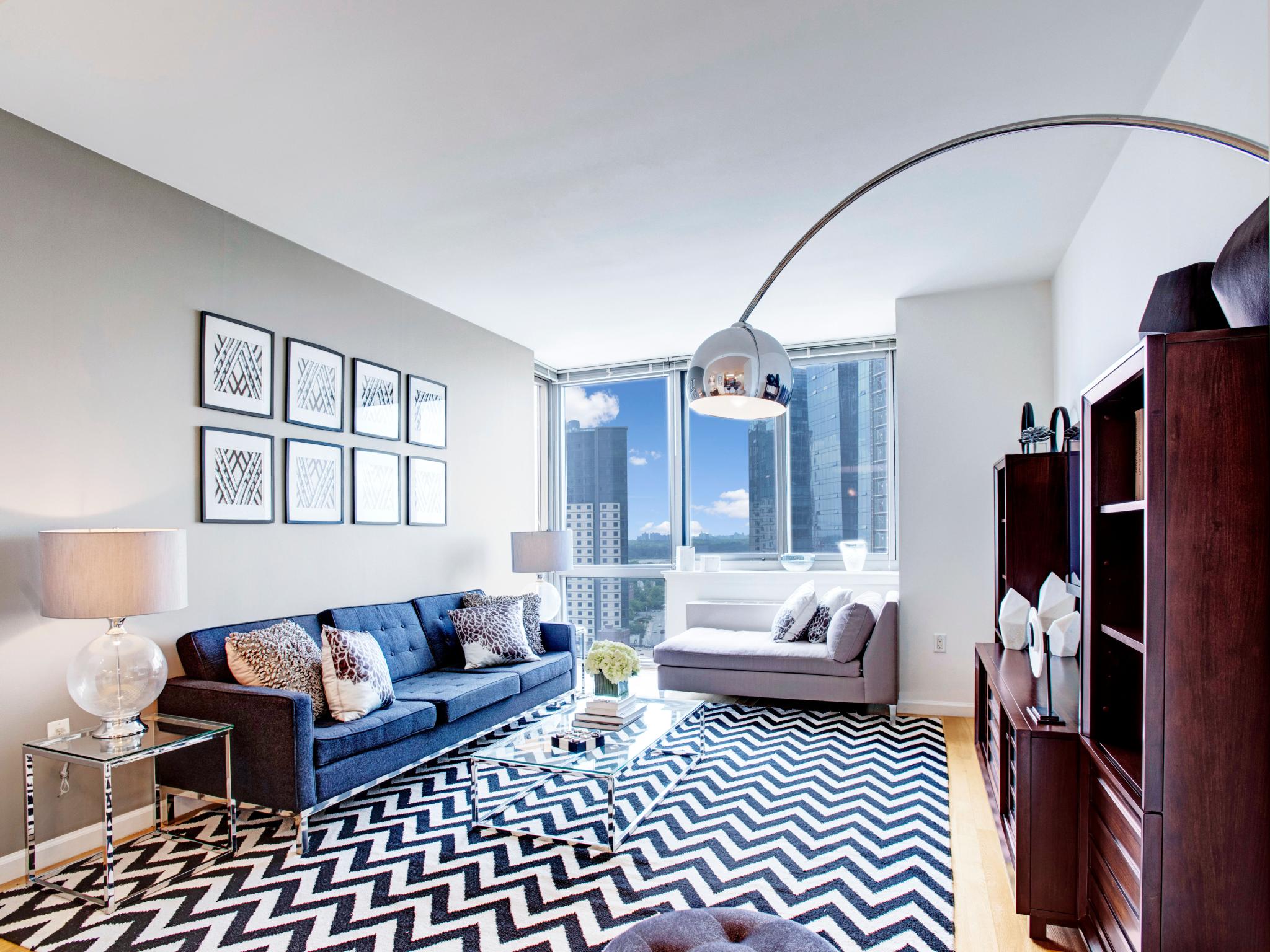 Bright and stylish living area at Skyline New Rochelle apartments, boasting floor-to-ceiling windows, chic décor, and expansive cityscape views.