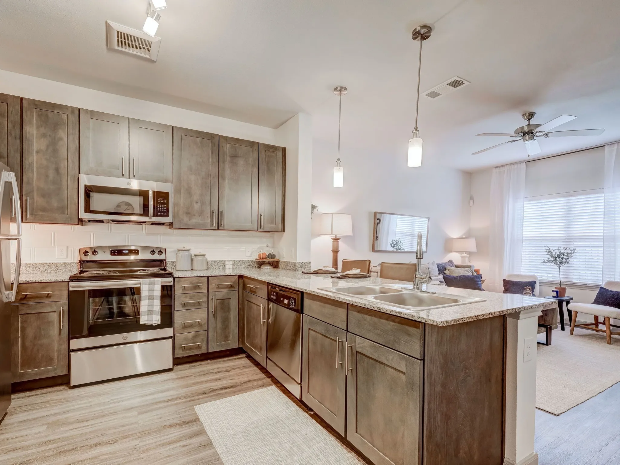 "Contemporary kitchen in an apartment at The Emerson at Forney with granite countertops, stainless steel appliances, and pendant lighting."
