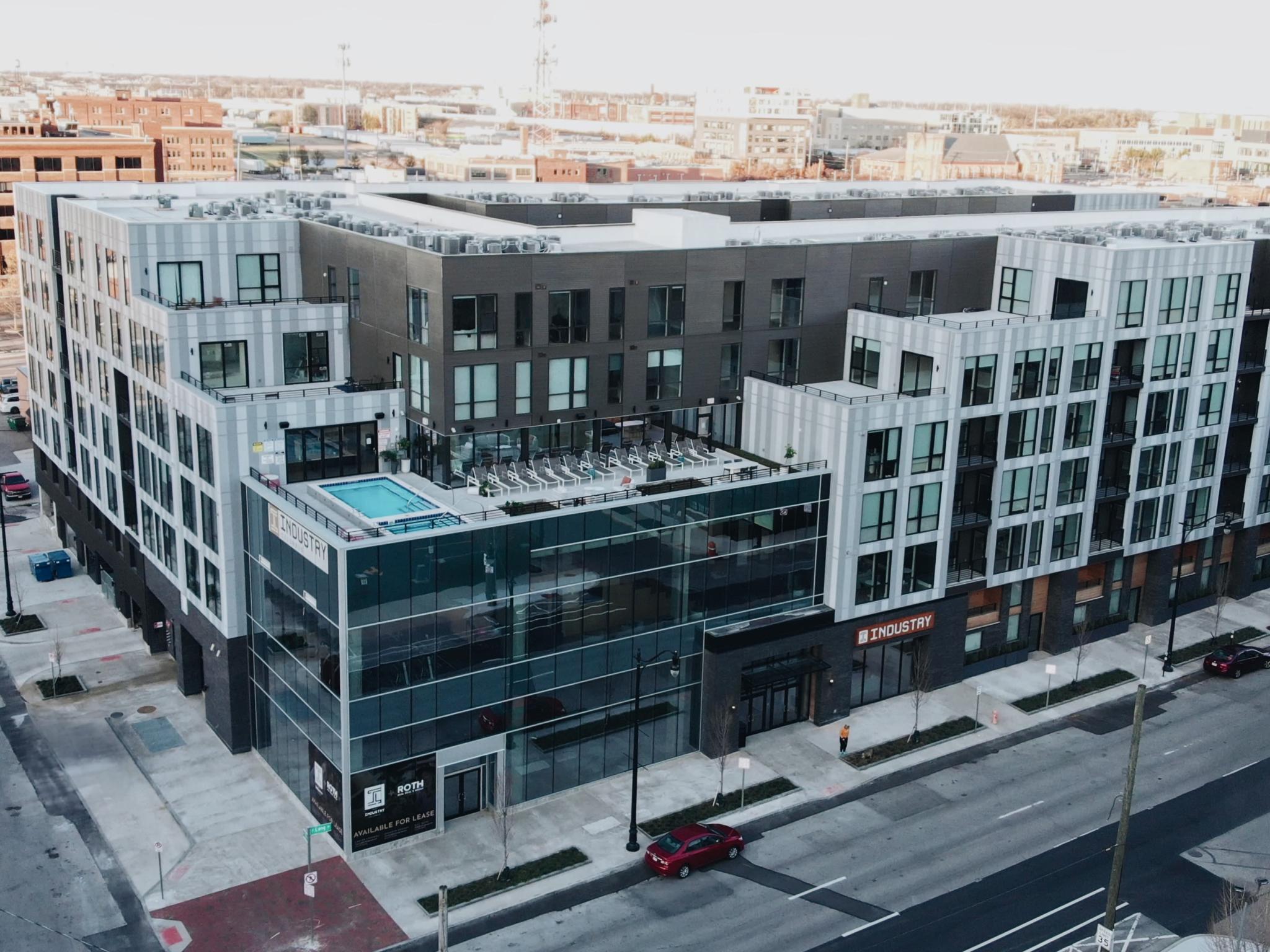 An aerial view of Industry Columbus Apartments, showcasing the contemporary exterior, rooftop pool, and surrounding cityscape in downtown Columbus.