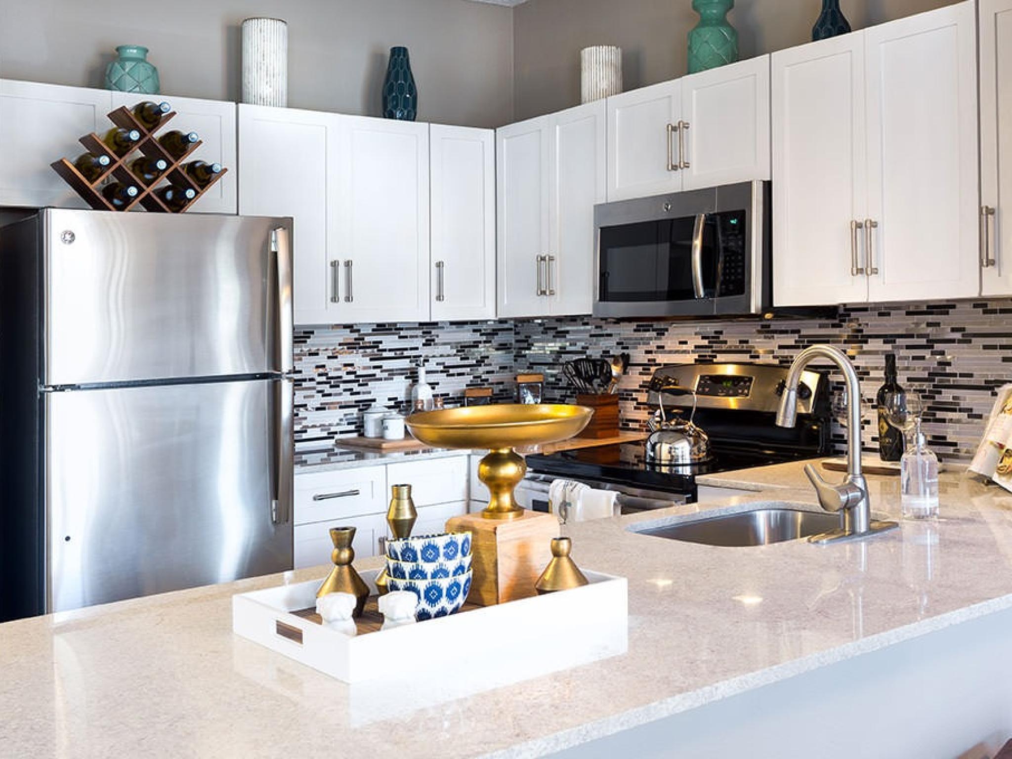 Bright, airy kitchen with elegant countertops and cabinets. Stainless-steel appliances create a slick atmosphere in Irving, Texas.