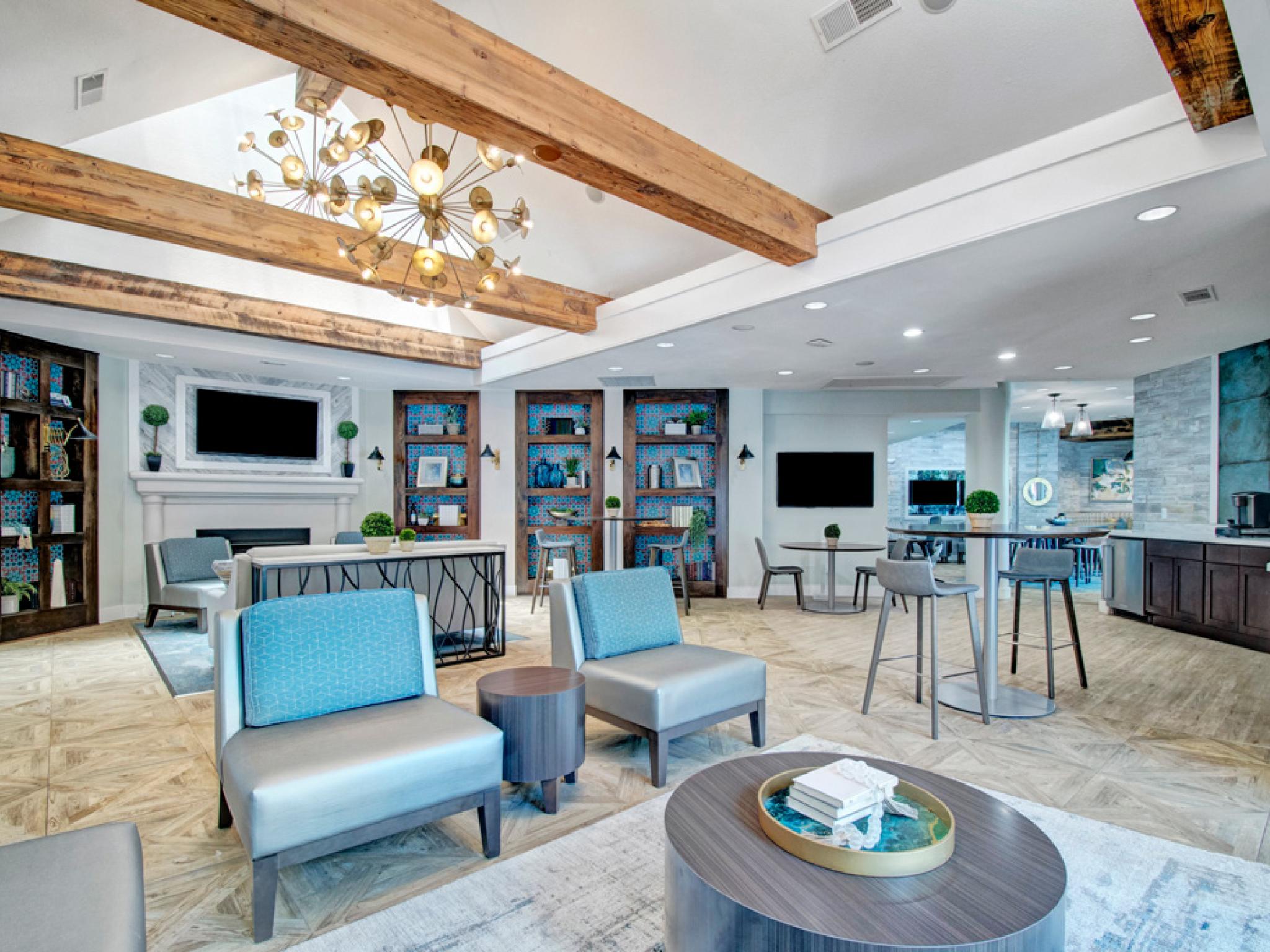 Large, upscale clubhouse with dedicated kitchen space, fireplace, and TVs for renters to come together and relax in Irving, Texas. 