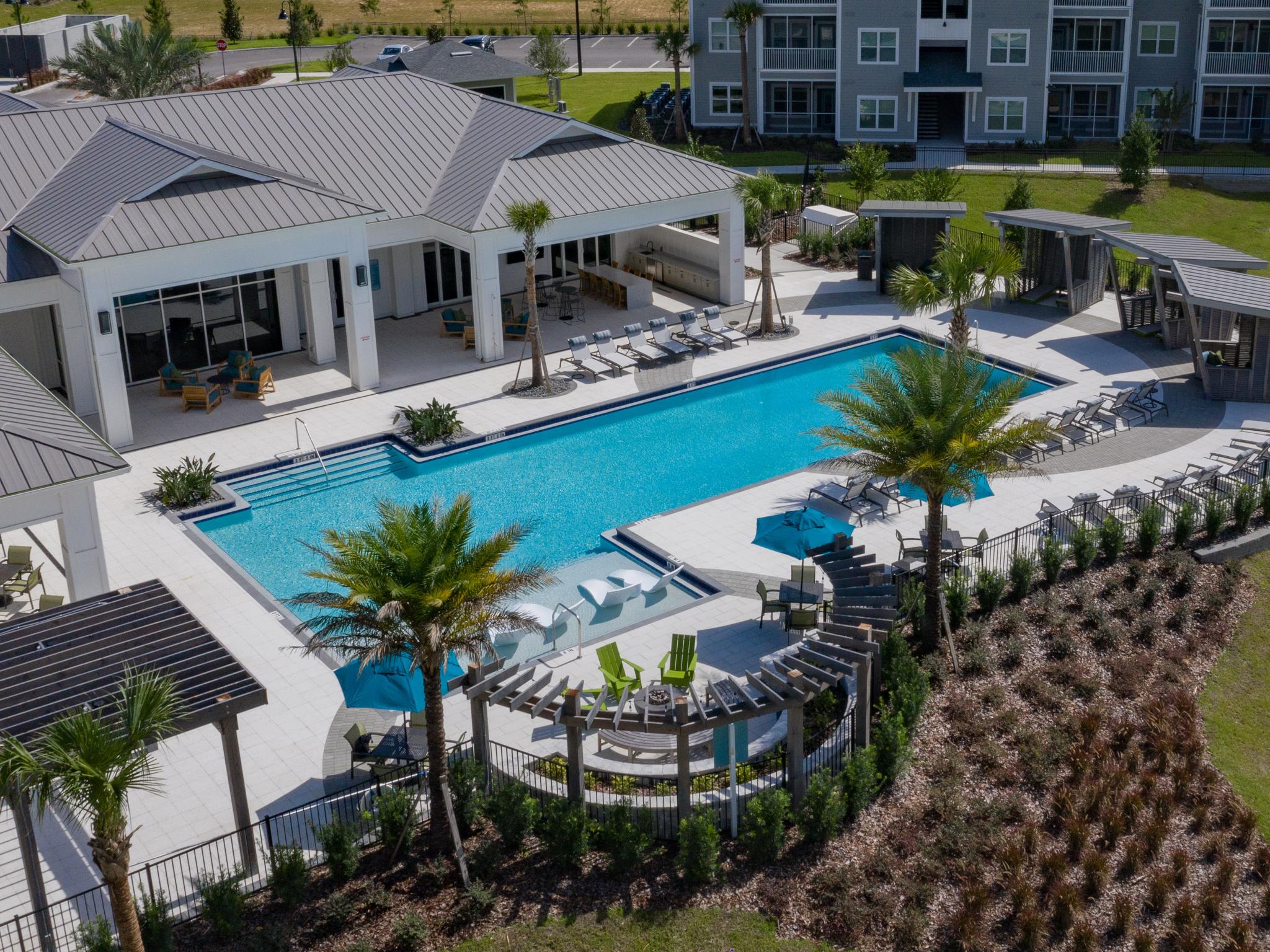 Incredible, sparkling resort style pool with luscious greenery.