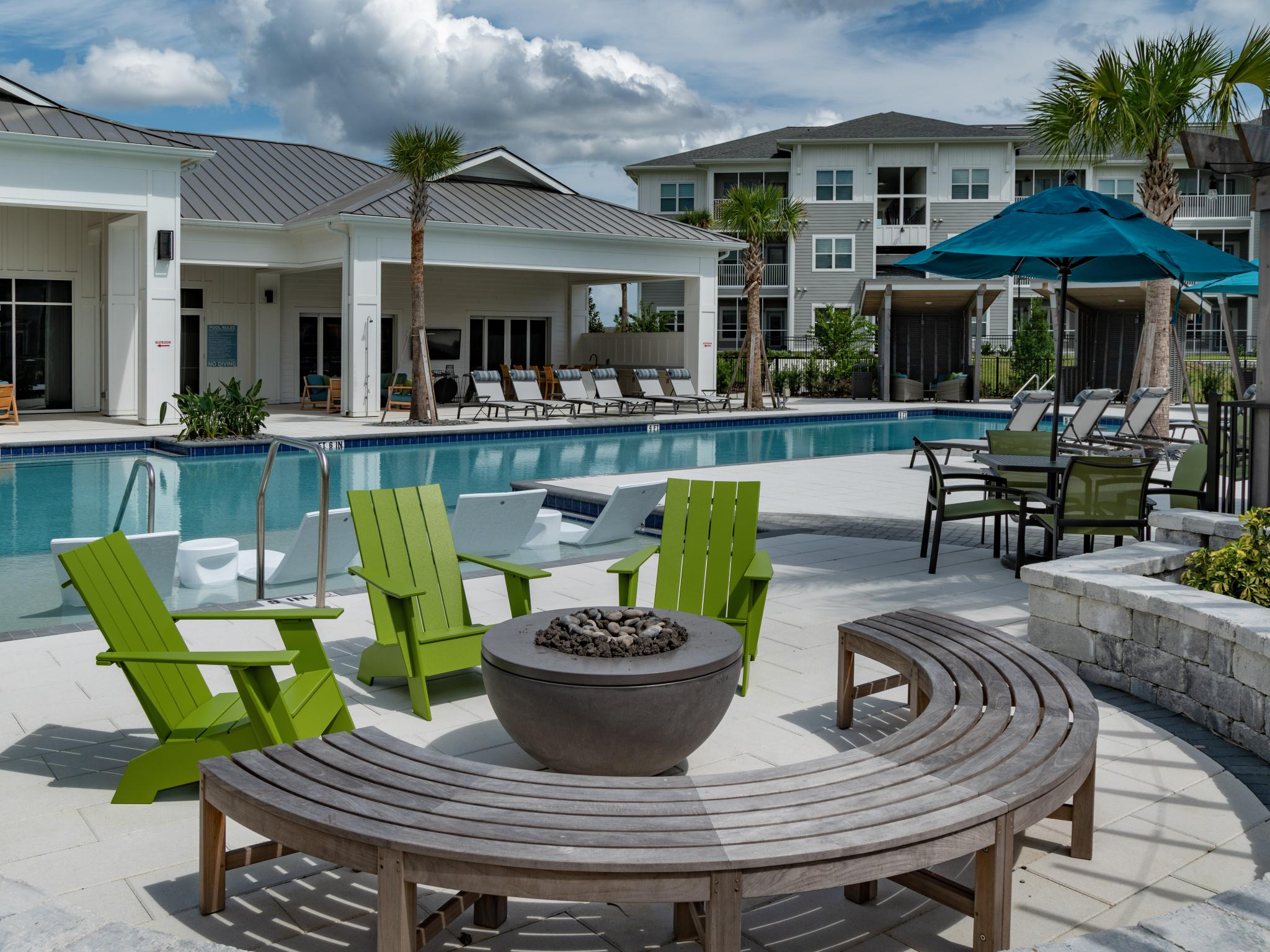 Ample outdoor seating next to a resort style sparkling pool and inviting fireplace.
