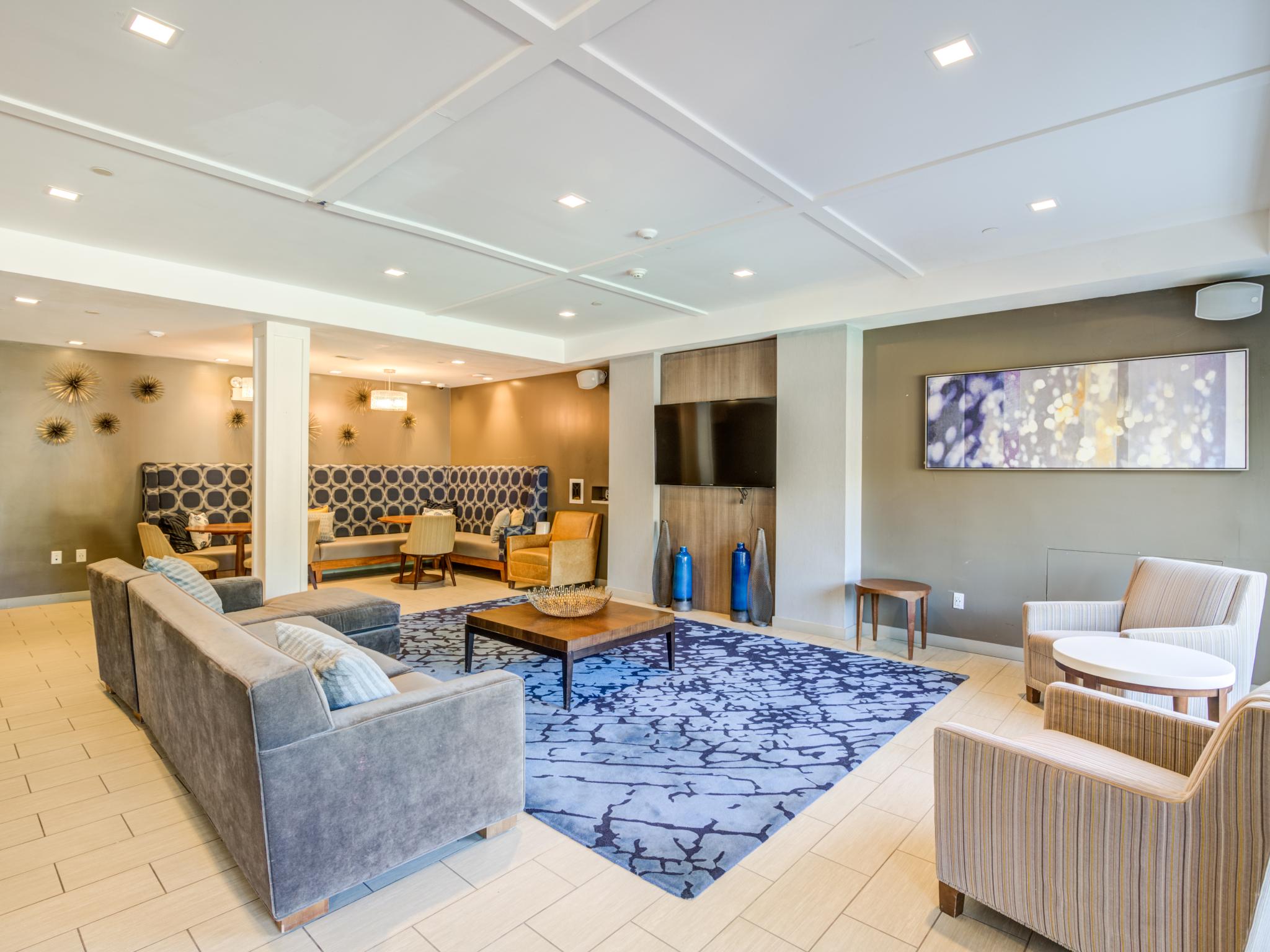 Large, open Clubhouse with multiple TVs, and ample seating for residents.
