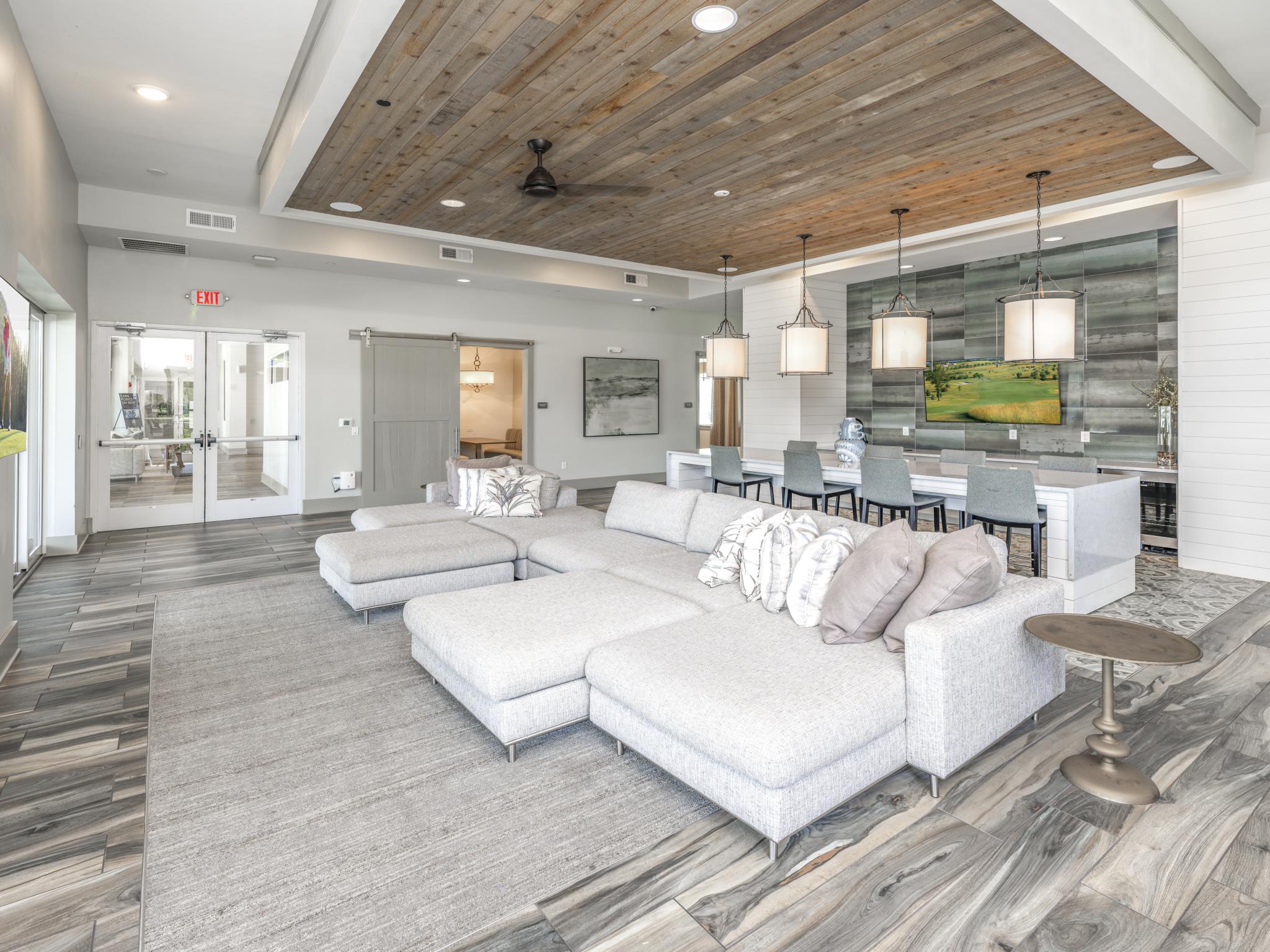 Cozy clubhouse with large, stylish couch and flatscreen TV.
