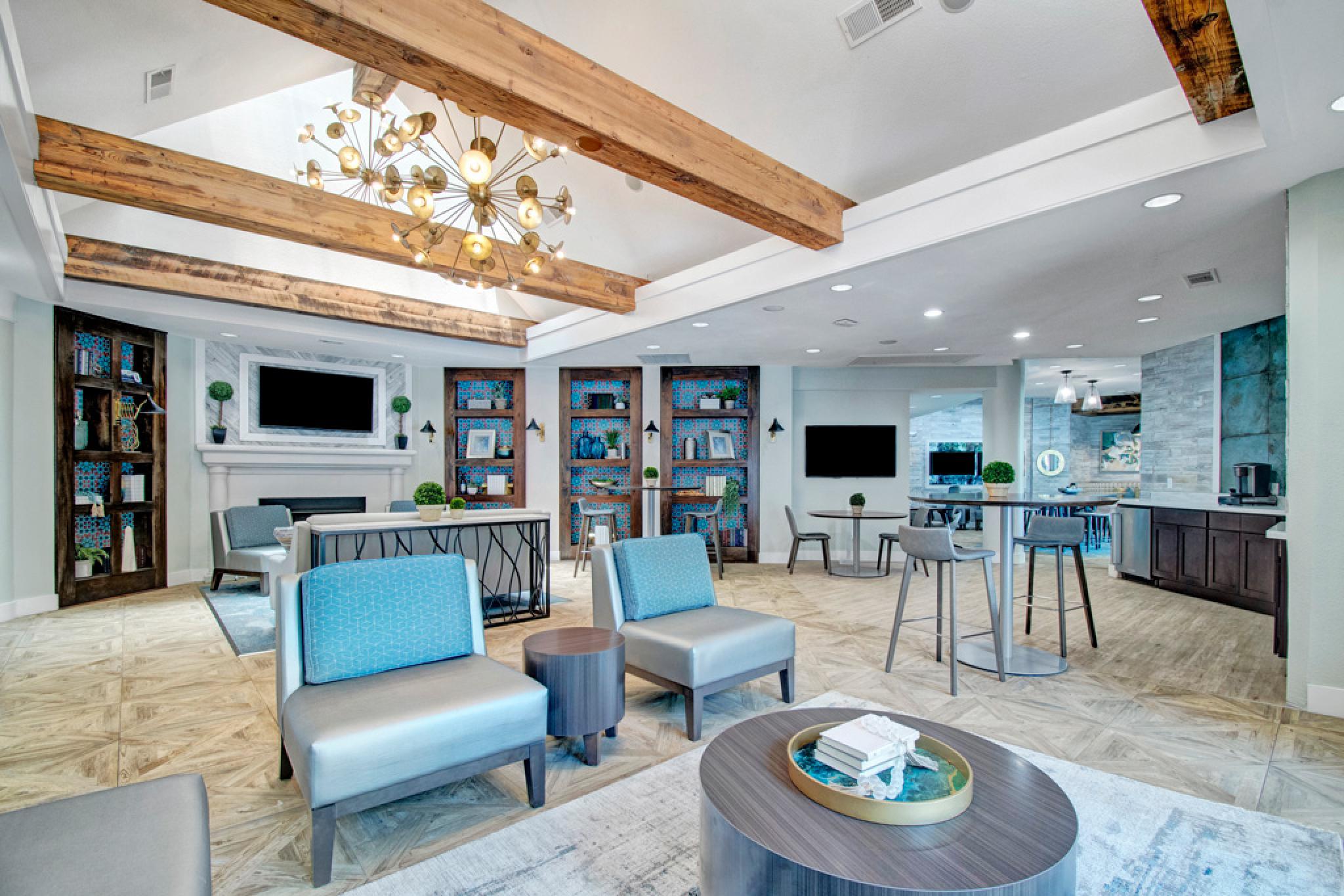 Large, upscale clubhouse with dedicated kitchen space, fireplace, and TVs for renters to come together and relax in Irving, Texas. 